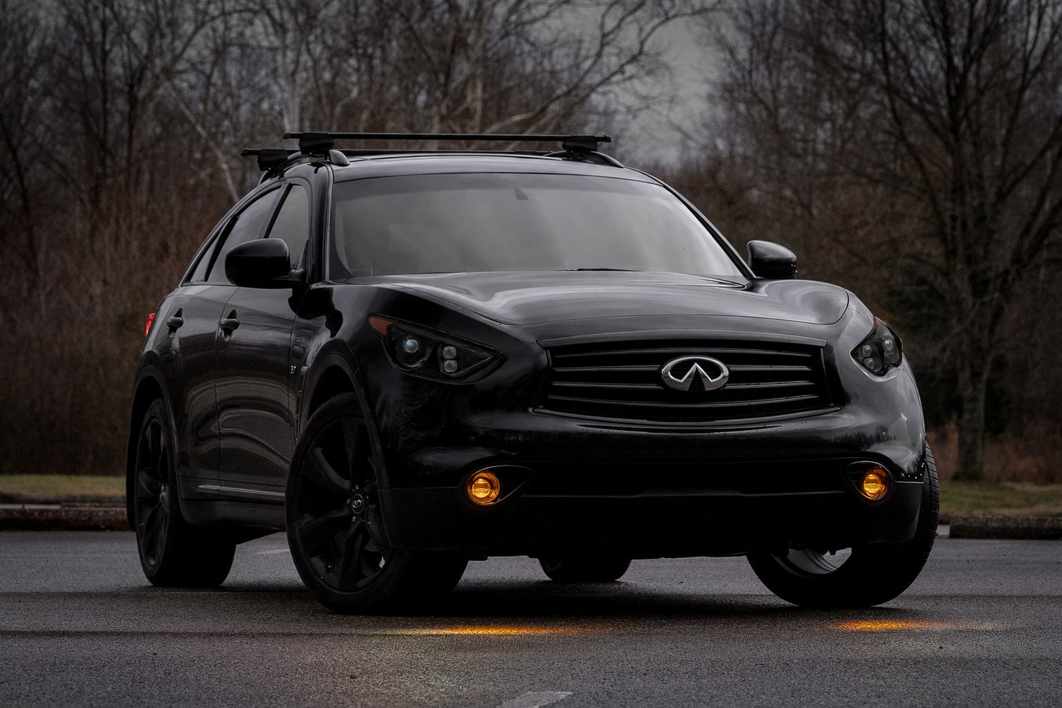 Black Infiniti QX70 with three EVO TRI projector lenses per headlight and amber fog lights