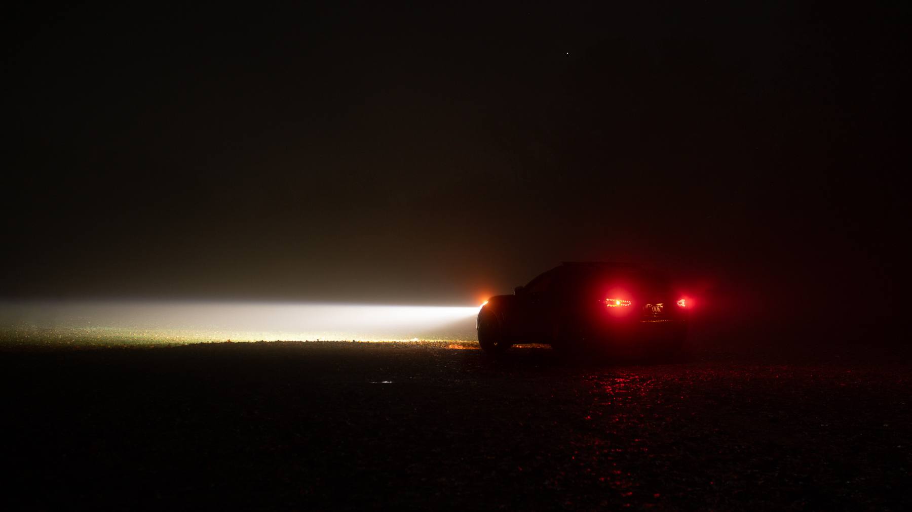 QX70 in heavy fog at night with the EVO TRI white beam cutting across the road